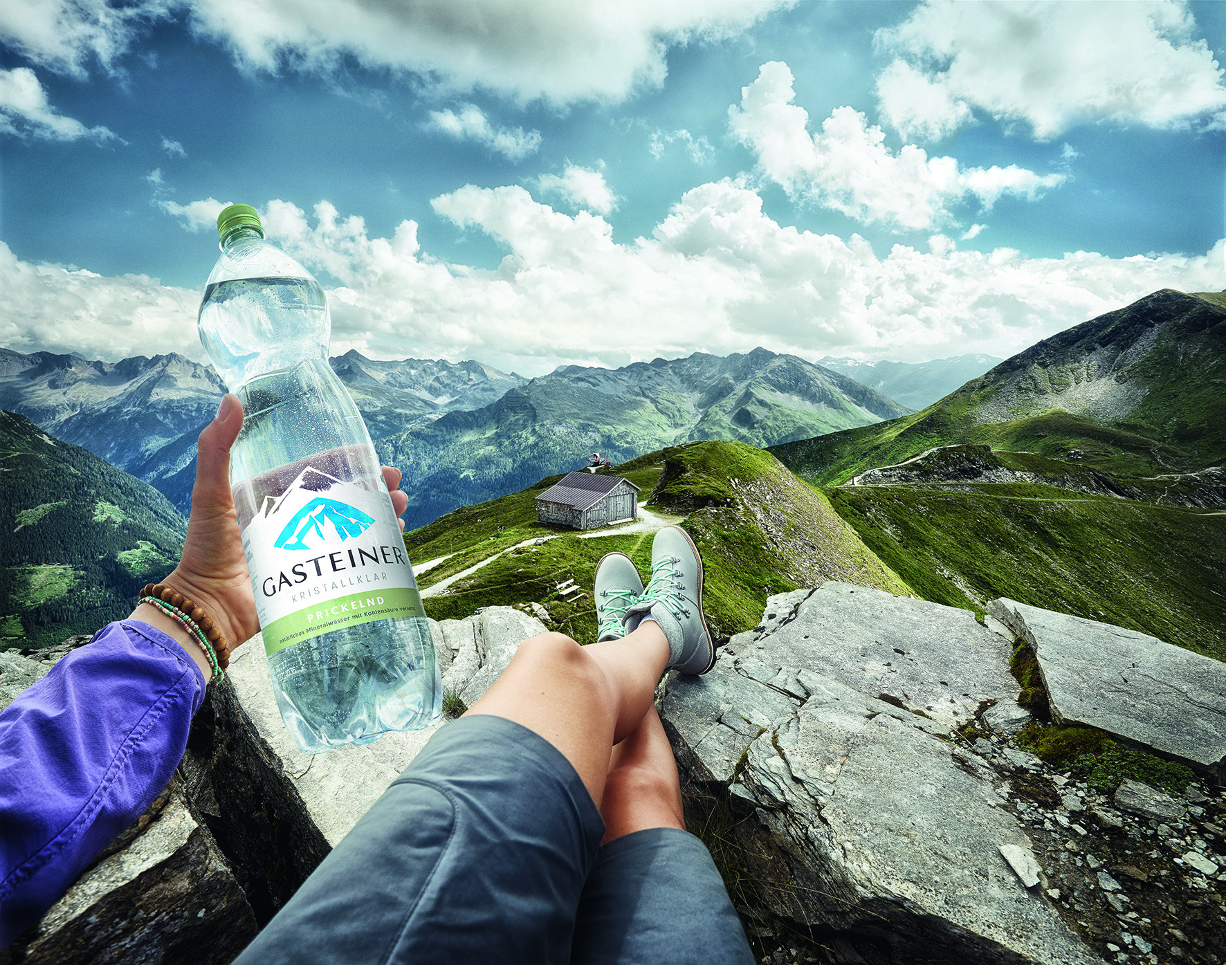 Kristallklares Gasteiner Mineralwasser in der PET-Literflasche am Berggipfel.